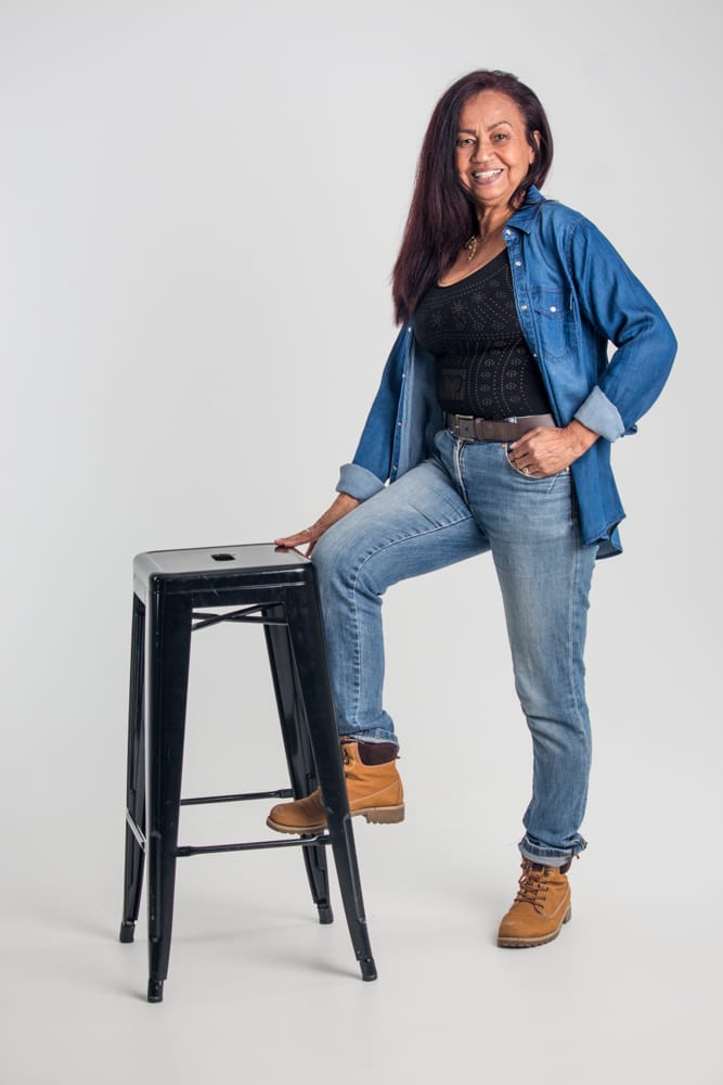 Elielza en jean, un pied sur un tabouret